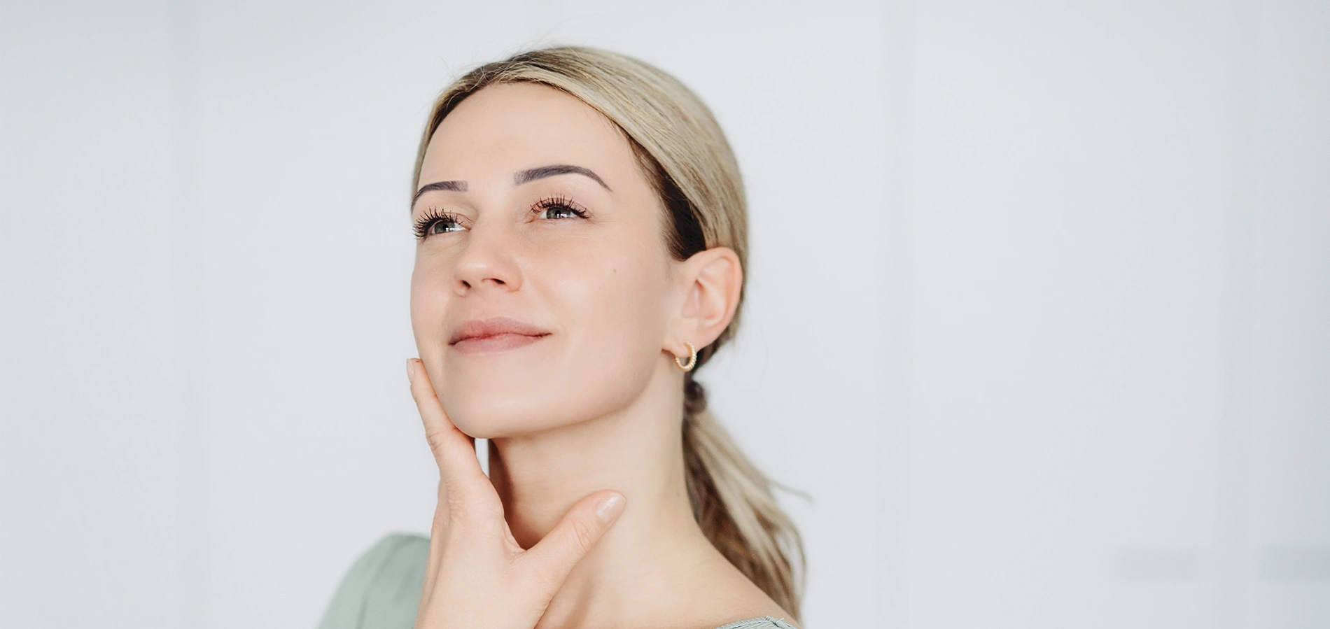 Schönheitsfoto einer Frau mit sauberer und gesunder Haut, die ihr Gesicht berührt