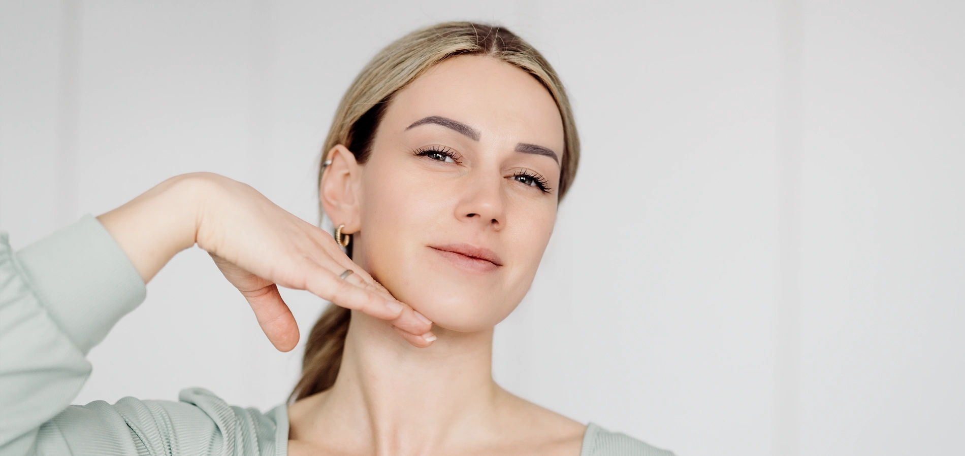 Schönheitsfoto einer Frau mit sauberer und gesunder Haut, die ihr Gesicht berührt